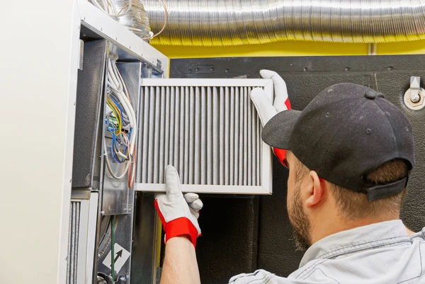 HVAC technician replacing furnace filter in Clinton Township MI
